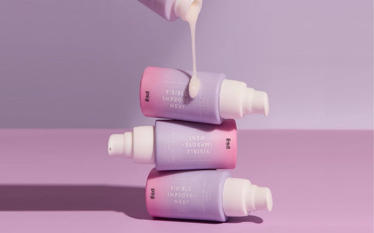 niacinamide and peptides serum stacked one on top of another on the pink background